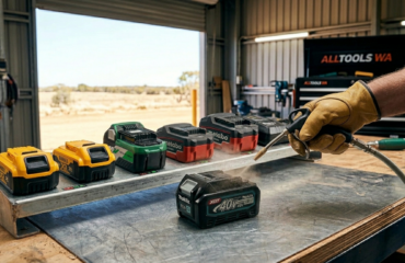 Professional power tool battery care: using a compressed air tool to safely clean terminals on a cordless battery in an Australian workshop.